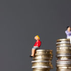 Egalité salariale : un homme et une femme sur des piles de pièces