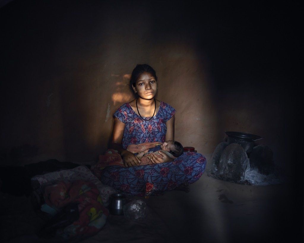 Saraswati, 16, must live in a closed dark room with her three day old baby because she bled after childbirth. They will be there for 15 days. Not only is Saraswati not allowed to clean herself, she must cook her food in the same tiny dark room even if it means choking her little baby with smoke. After childbirth she developed serious health disabilities. Because of staying in the Chhau and rarely being allowed to step outside, her legs are now swollen to a point she can barely walk. She suffers from serious stress disorder and often had breakdowns. She barely spoke a word to me. Nepal, 2016.
